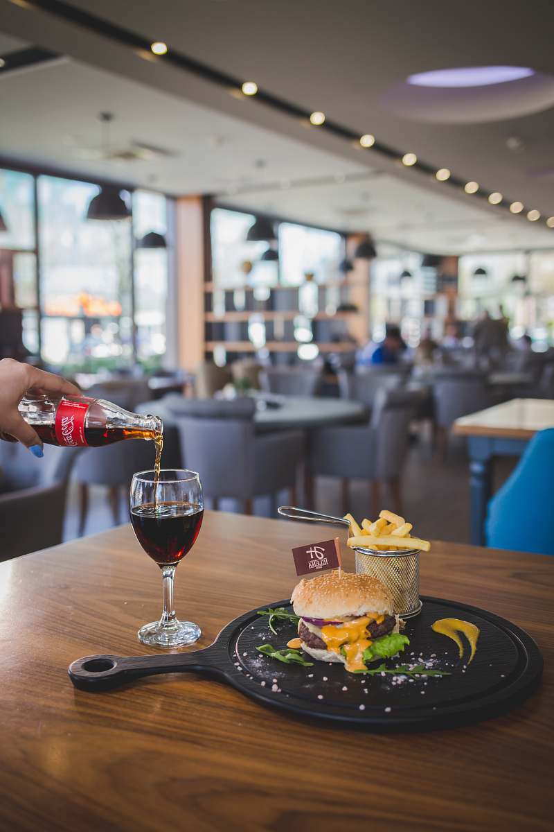 dining table black tray with cheese burger beside footed glass filled with coca-cola furniture